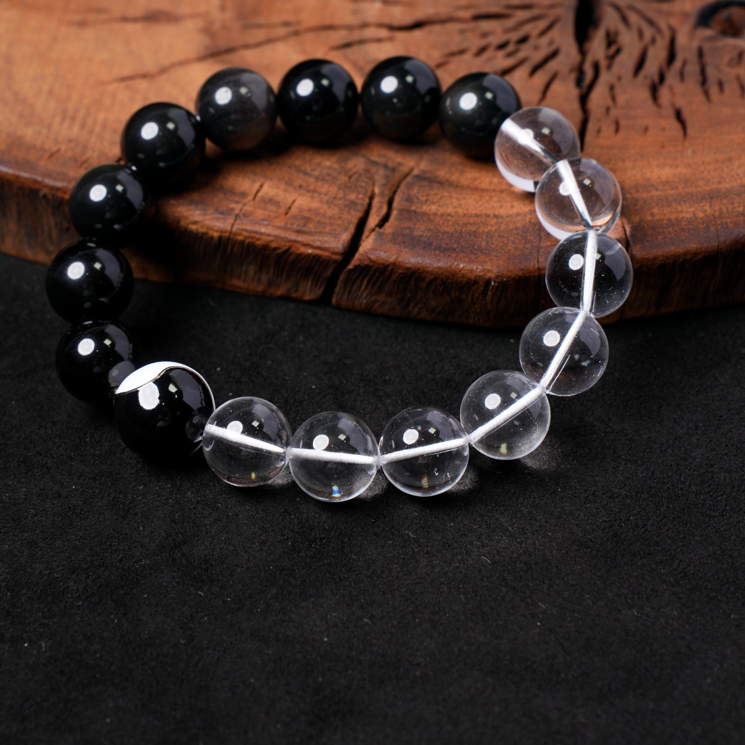 Detailed close-up of Nuwa Stone's "Clarity & Shadow Balance" bracelet, showcasing the smooth, round silver obsidian and clear quartz beads, highlighting their luster and natural variations.