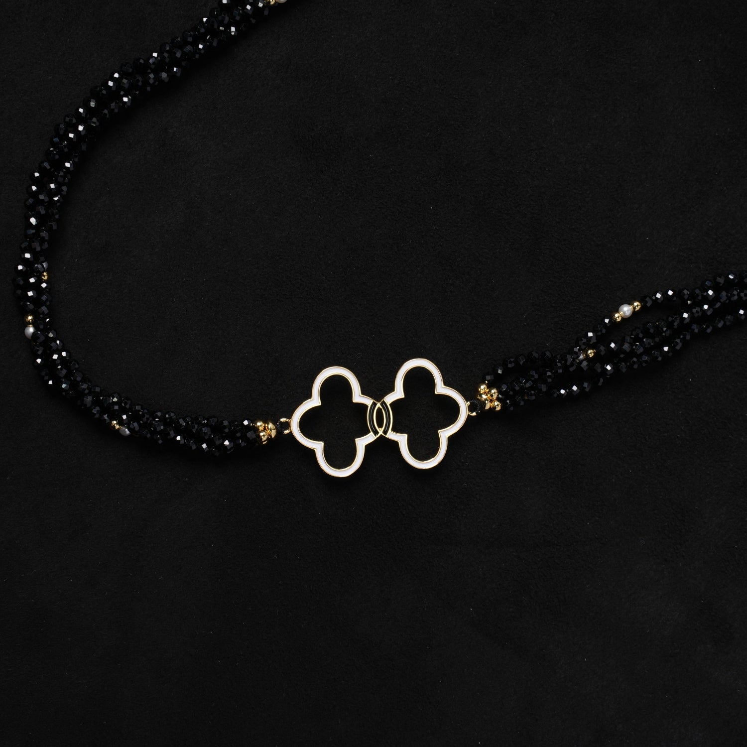 Another view of Nuwa Stone's "Nightfall Galaxy Cascade" multi-strand necklace, showcasing its full length, the interplay of black spinel and pearls, and the gold-plated toggle clasp on a dark wooden surface.
