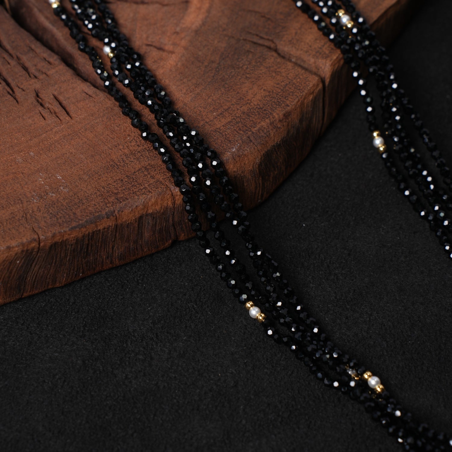 Detailed close-up of the multiple strands of faceted black spinel beads interspersed with delicate white pearls in Nuwa Stone's "Nightfall Galaxy Cascade" necklace, highlighting the sparkle and texture.